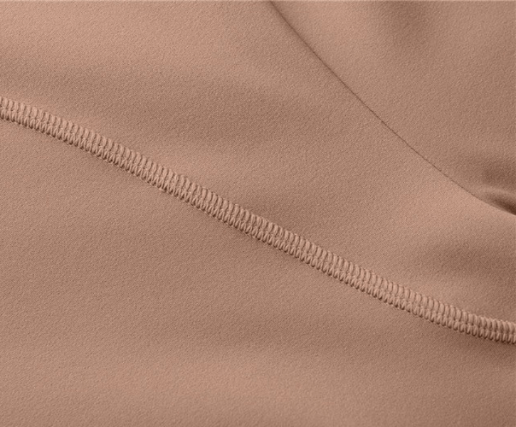 Close-up of elastic fabric detail on women's sports sweatshirt, showing stitching and texture.
